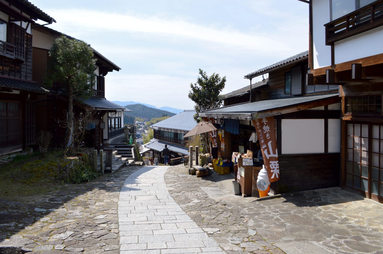 斜面をのぼる馬籠の石畳の坂。黒い木造の宿や店が軒を連ねます。