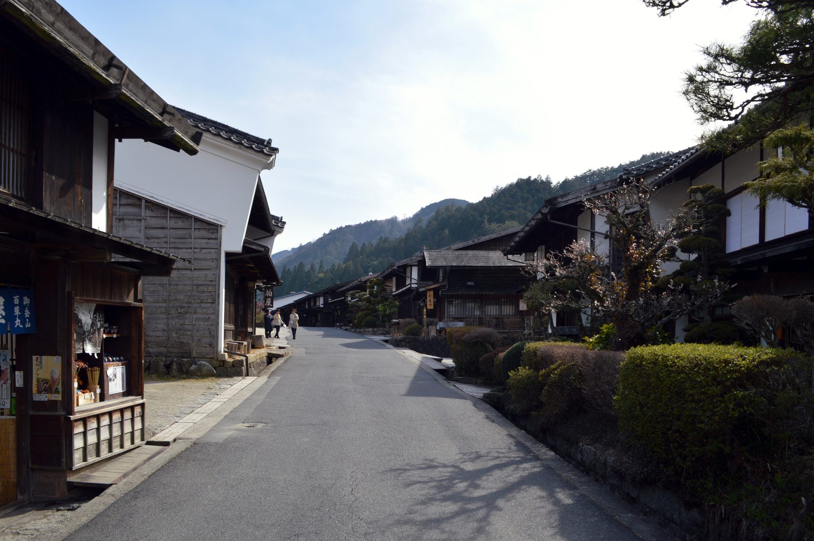 美しく保たれた妻籠の平らな目抜き通り。深い軒の下に黒い木造の宿が並びます。