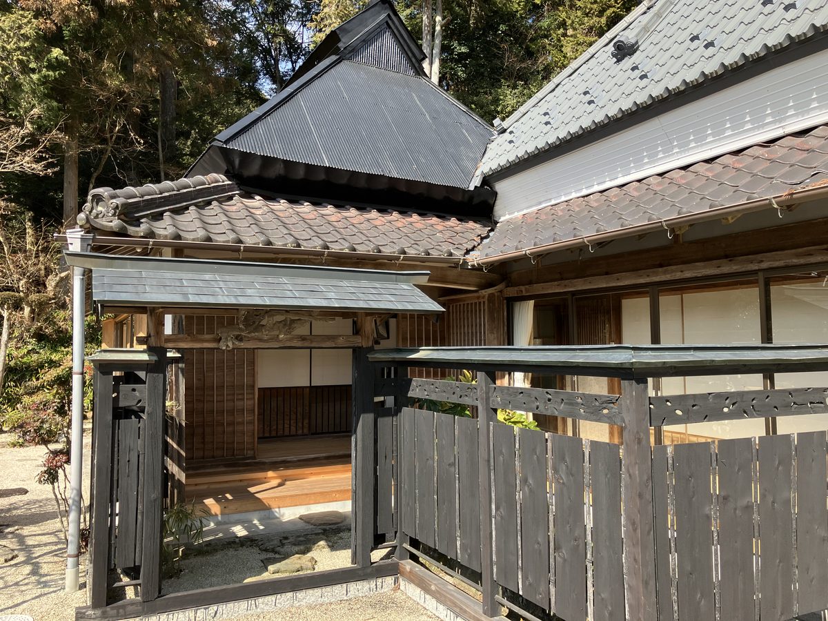 The historic farmhouse atelier, with its tiled roof and covered entrance gate.
