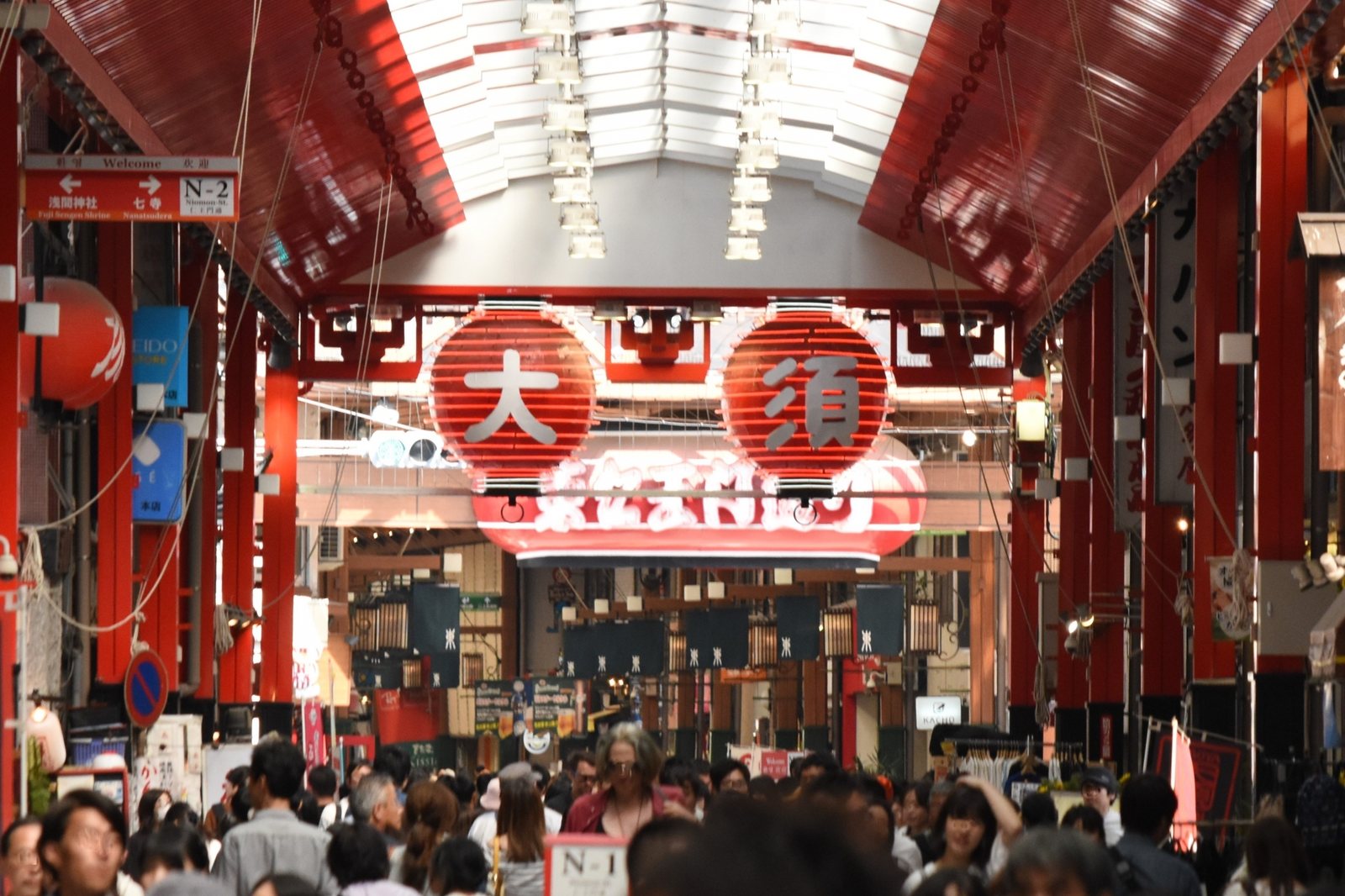 Under the big 'Osu' lanterns, the covered arcade fills with shoppers and snackers.